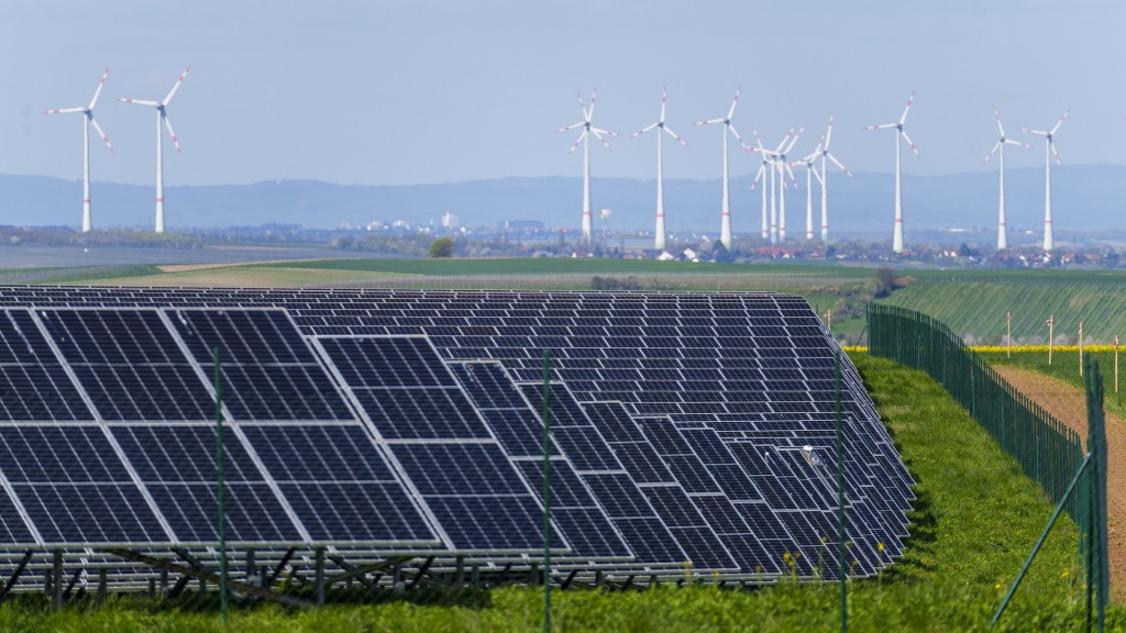 Ein Solarpark steht in der Nähe zu mehreren Windkraftanlagen.