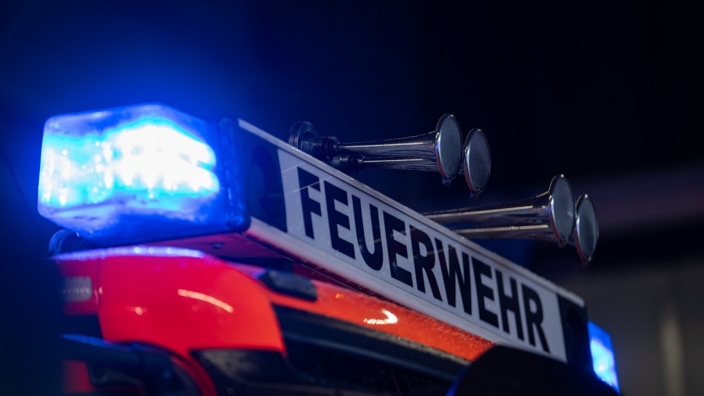 Ein Einsatzfahrzeug der Feuerwehr steht mit Blaulicht bei der Feuerwache