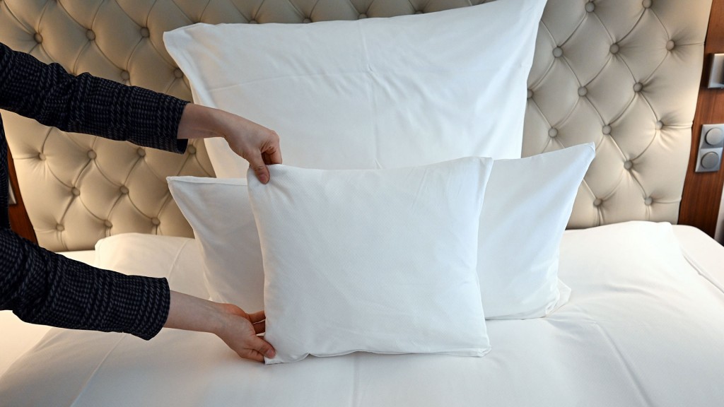 In einem Hotelzimmer wird ein Bett hergerichtet