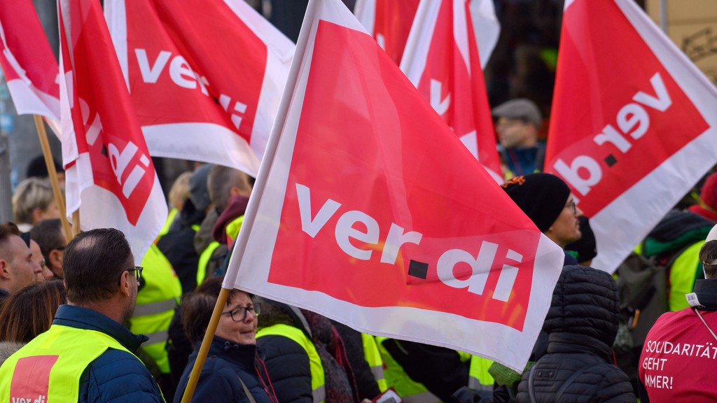 Streikende stehen mit Verdi-Fahnen