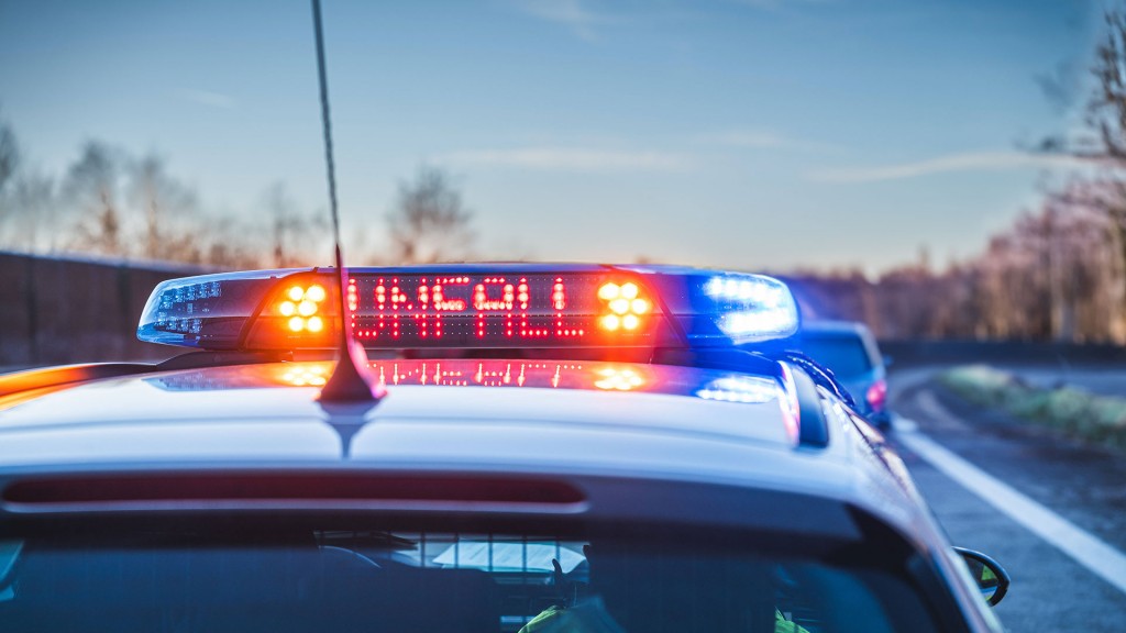 Ein Polizeifahrzeug sichert mit Blaulicht eine Unfallstelle ab