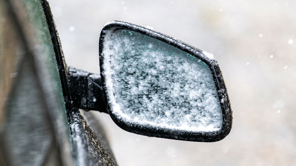 Der verschneite Seitenspiegel eines Autos