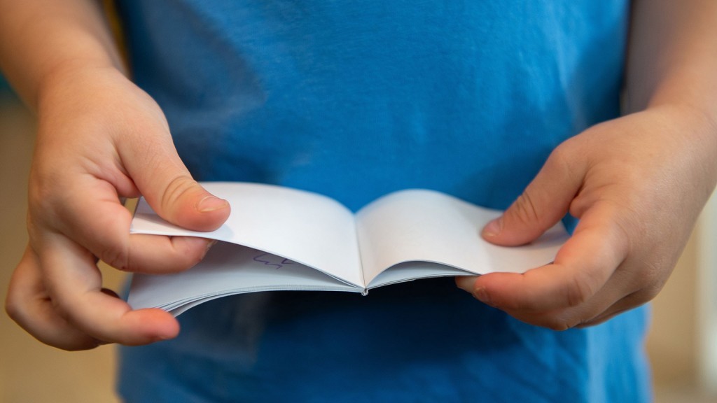 Foto: Kinderhände blättern in einem Notizbuch