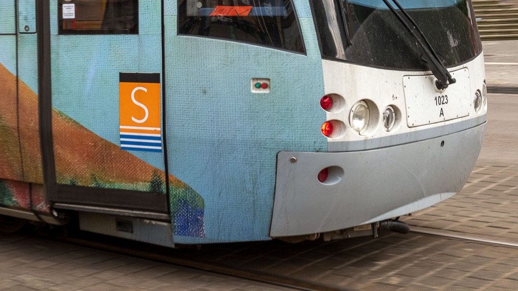Das Logo der Straßenbahn auf einem vorbeifahrenden Schienenfahrzeug