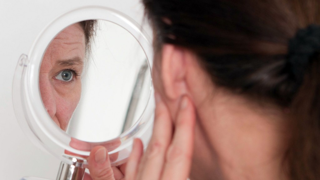 Eine Frau betrachtet sich in einem Spiegel