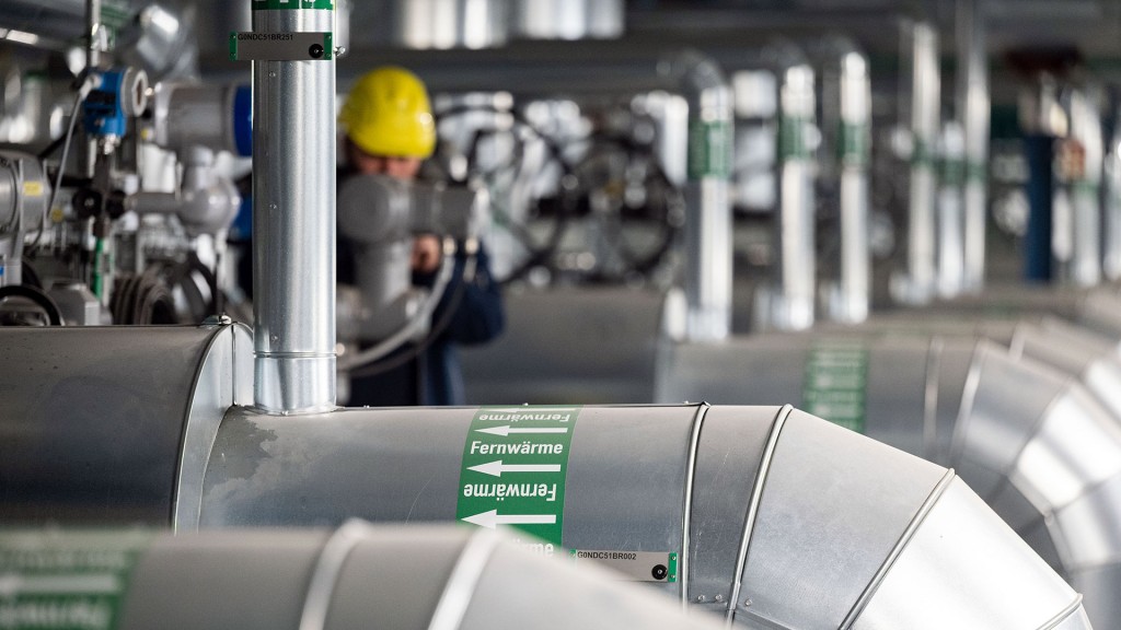 Ein Techniker kontrolliert Wärmeleitungen in einem Heizkraftwerk