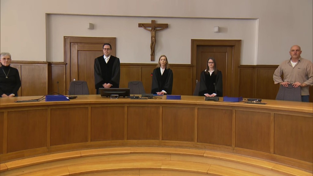 Foto: Landgericht Saarbrücken. Richter stehen an der Richterbank vor der Verkündung des Urteils.