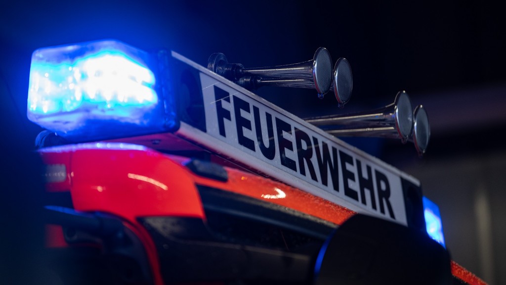 Ein Einsatzfahrzeug der Feuerwehr steht mit Blaulicht bei der Feuerwache