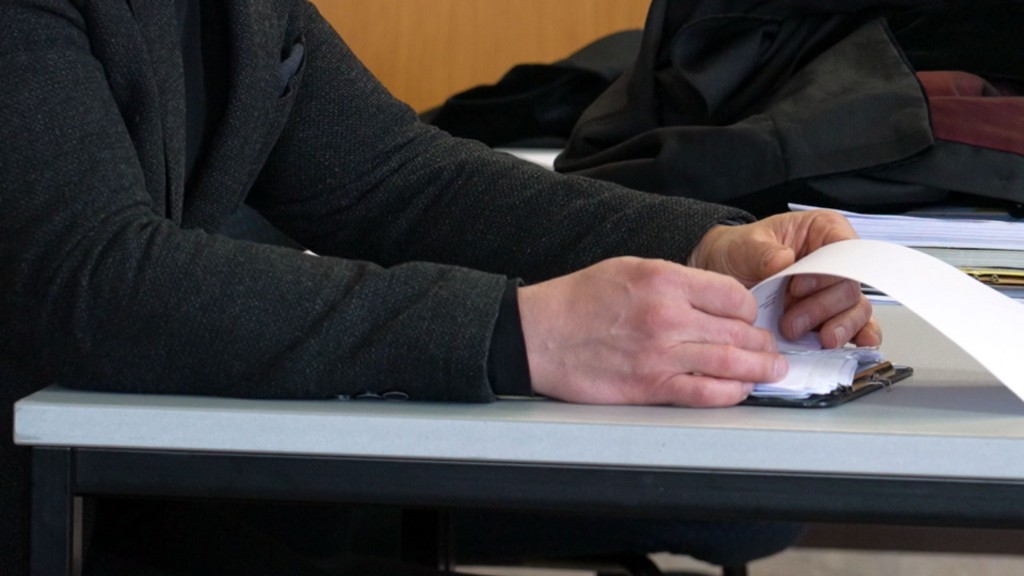 Foto: Jemand blättert bei einem Gerichtsprozess Unterlagen durch