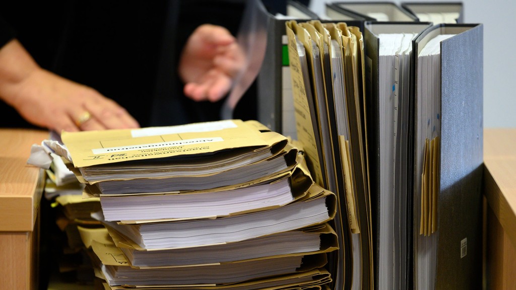 Foto: Mehrere gefüllte Aktenmappen und Ordner stehen auf einem Tisch