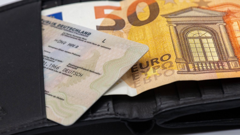 Personalausweis-Kosten_2026 Personalausweis in Portemmonaie und darunter ein 50-Euro-Geldsschein. 