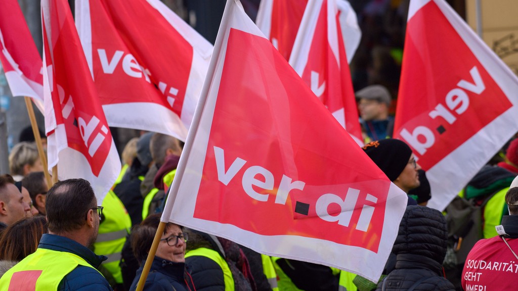 Streikende stehen mit Verdi-Fahnen