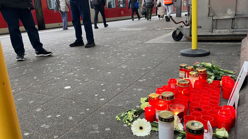 Foto: Blumen und Grablichter zum Gedenken an den getöteten Zugbegleiter liegen an einem Bahnsteig