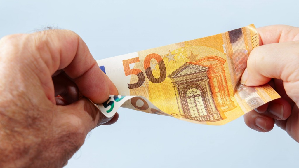 Mann hält Geldschein in der Hand 