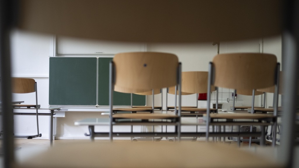 Foto: Stühle und eine Tafel sind in einem leeren Klassenzimmer zu sehen.