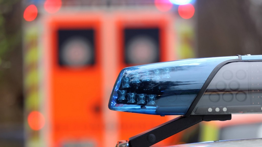 Foto: Polizeiblaulicht mit einem Krankenwagen im Hintergrund