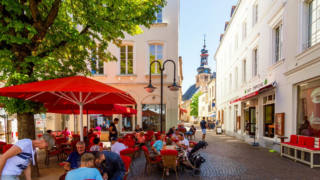 Menschen sitzen bei sonnigem Wetter am Sankt Johanner Markt im Schatten