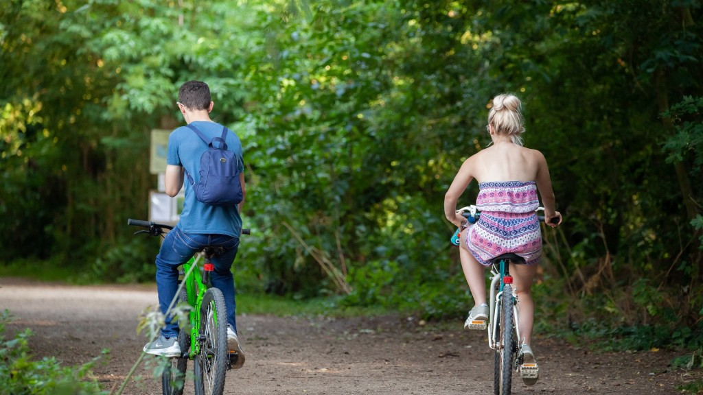 Zwei Teenager fahren mit dem Rad durch einen Waldabschnitt