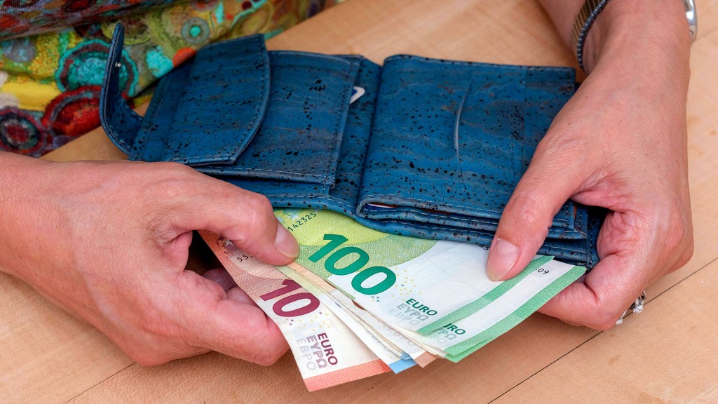Eine Frau zieht Geldscheine aus ihrem Portemonnaie