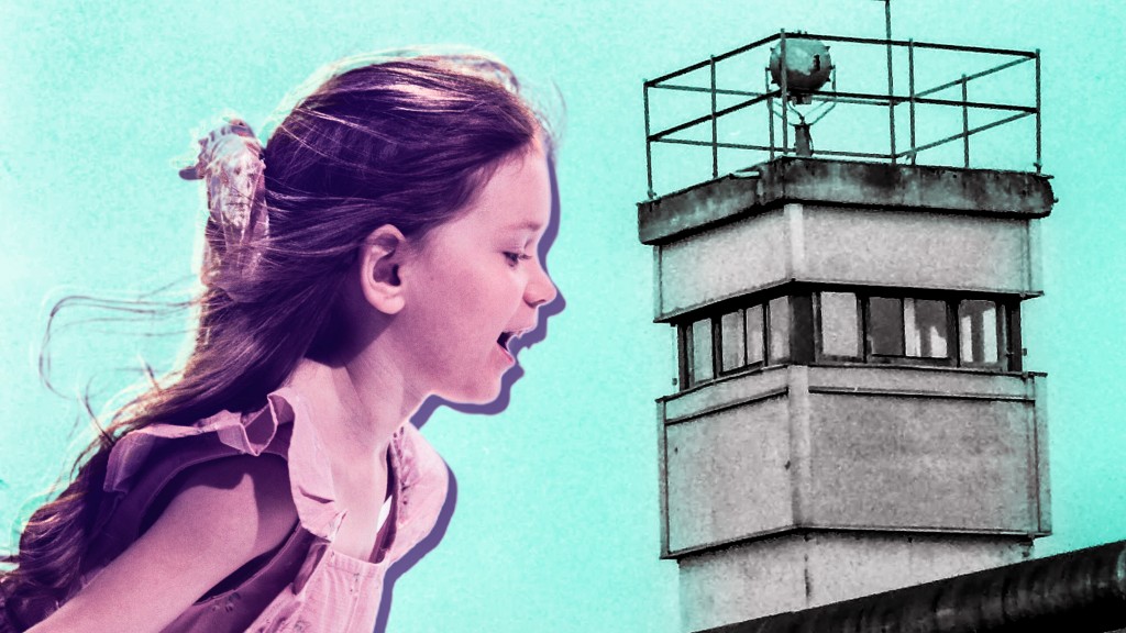 In der Collage steht links ein Mädchen, welches lachend über die graue Grenzmauer zwischen der DDR und der BRD schaut. Rechts steht ein Wachturm.   