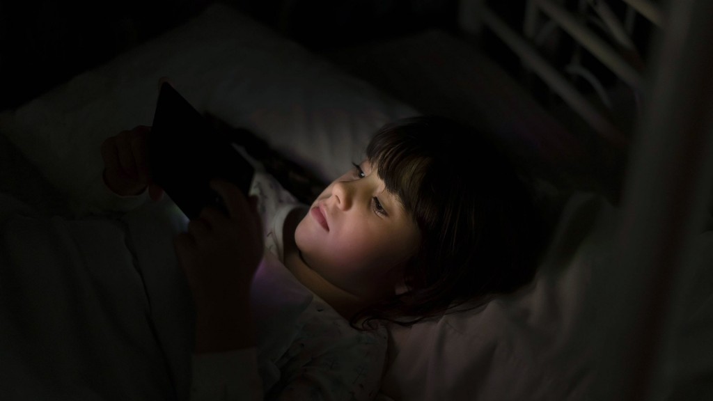Symbolbild: ein Kind liegt mit Smartphone auf dem Bett