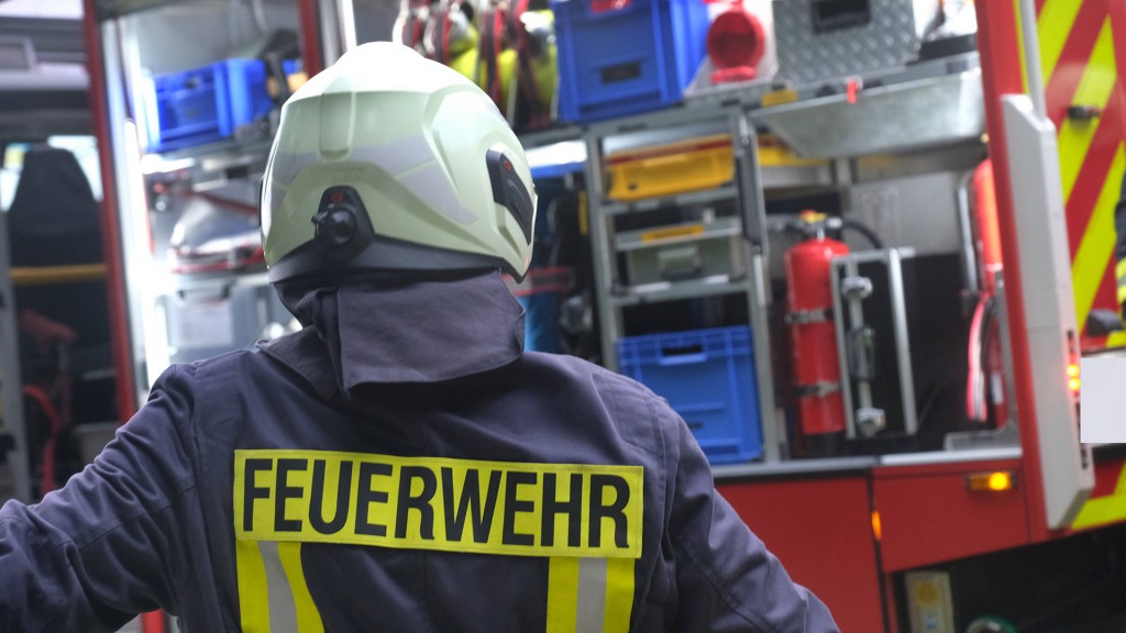 Foto: Ein Feuerwehrmann steht vor dem Gerätewagen