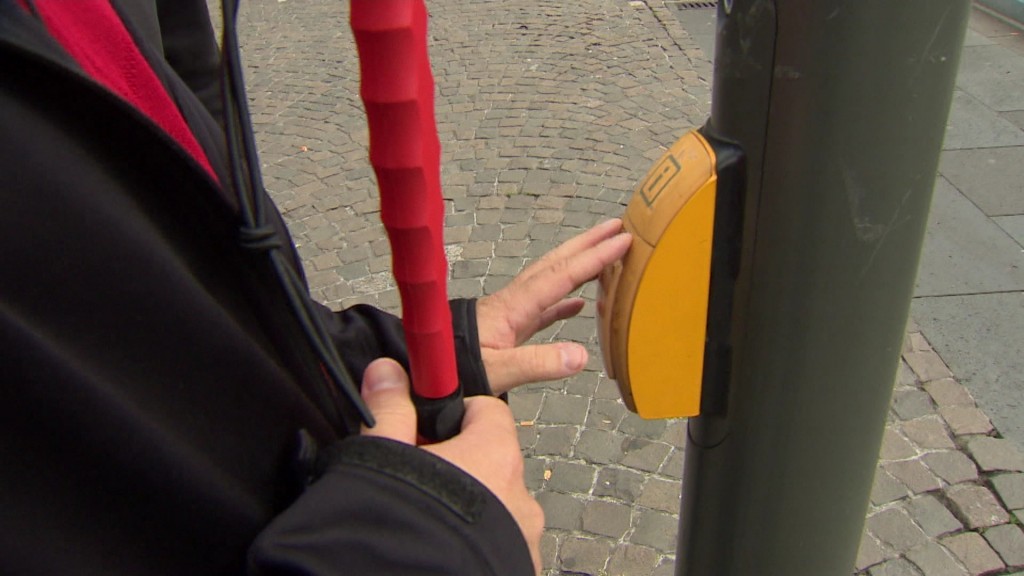 Mann mit Blindenstock an Ampel
