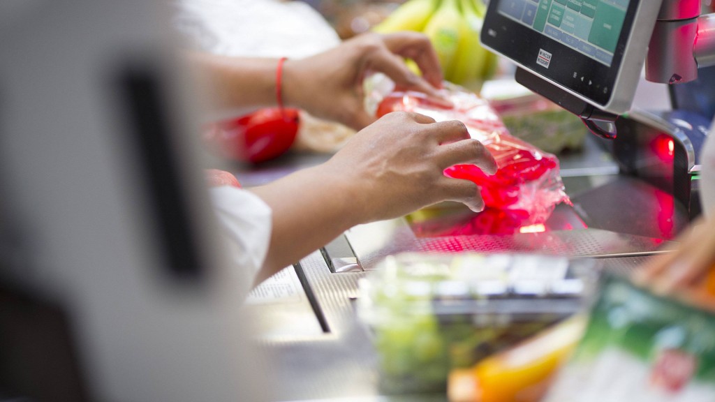 Foto: Eine Mitarbeiterin scannt an der Kasse eines Supermarkts Waren.